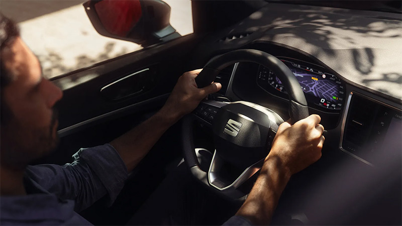 Muž řídí vůz SEAT Ateca, detail na multifunkční volant