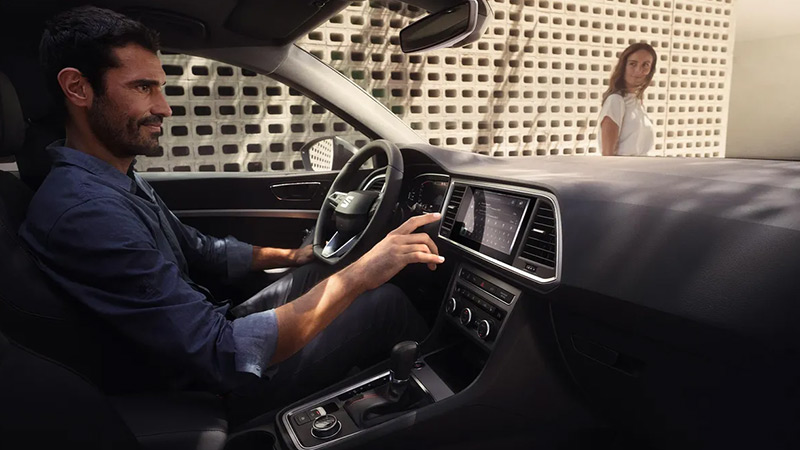 Muž nastavuje funkce na digitálním panelu ve voze SEAT Ateca