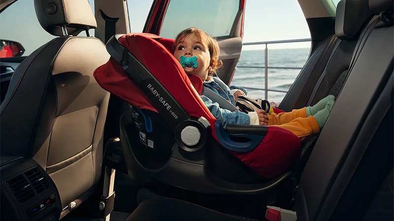 Dětská sedačka s batoletem, umístěná na zadních sedadlech vozu SEAT Leon