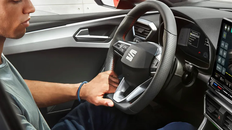 Muž řídící vůz SEAT Leon - detail na volant