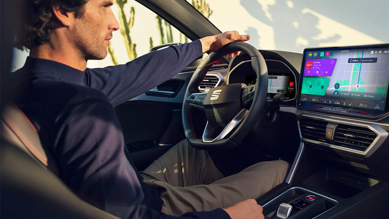 Muž sedící ve voze SEAT Leon - pohled na přístrojový štít