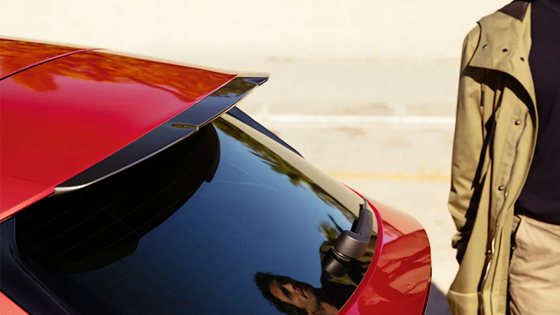 Pohled na střešní spoiler SEAT Leon, kolem prochází muž